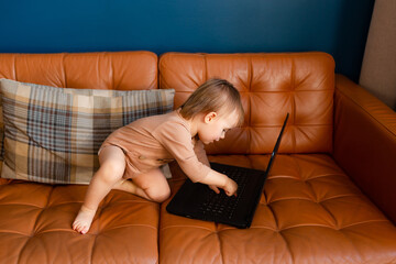 Baby with laptop at home. One year old baby typing on laptop.