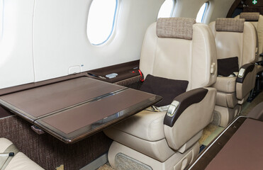Luxury bright leather interior of a modern commercial airplane. Inside of a small business...