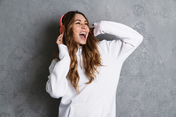 Cheerful lovely girl listening to music with headphones