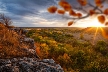 Autumn sunset. The rocks overlook the forest and steppe