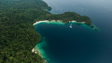 Aerial View Of Triton Bay, Raja Ampat Islands: Boat In Lagoon With Turquoise Water And Green...