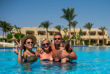 Fototapeta na wymiar Real people concept, beautiful family, two teenage girls, mother and father swimming and having fun in pool in vacation. happiness and nice body for enjoyed people live an lifestyle as vacation