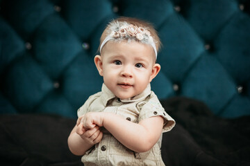 Baby Girl Sits on a Dark Background