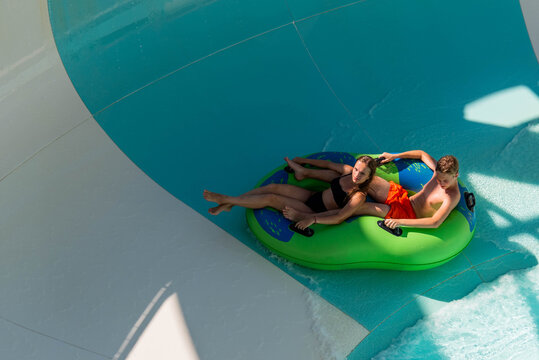 Girl and boy in water Park. Fun on the water. Teen girl and boy having fun in the water slider . Happy children's vacation outdoor.