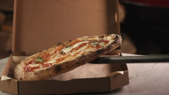 Packing Italian Neapolitan pizza kurerskoy delivery in a cardboard box
