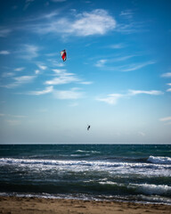 Windy beach with kite surfer jumping on the background