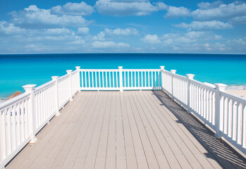 Panoramic view of the Caribbean Ocean with the clear turquoise water of the Mexican coast, from a white wooden terrace on the beach of Cancun