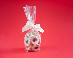 Homemade biscuits with jam in pack on red background