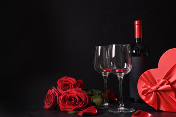 Red wine, chocolate sweets, roses with gift for Valentine's day. Greeting card with copy space.