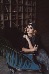 Portrait of a beautiful stylish blonde woman in a knitted headband in a loft interior. Soft selective focus, defocus. No retouching.