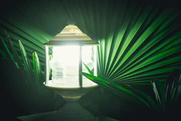 Night lamp in palm leaves. Night and light from a lantern. - 412921455