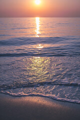 The sun rises on the sea coast. Calm water. Pink-lilac dawn. - 412922292