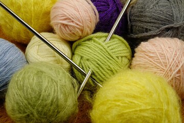 Balls of colored yarn for knitting on a dark wooden black background