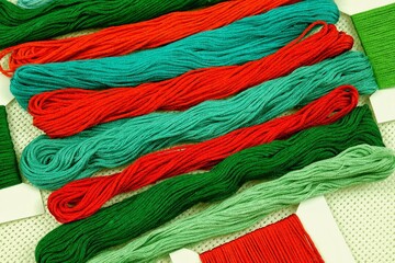 Multicolored embroidery threads in red and green tones