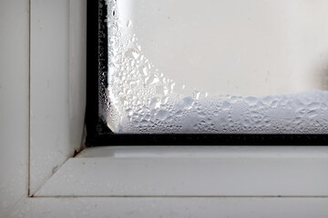 Condensation on the defective plastic window. Weeping double glazed windows in winter