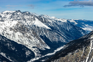 Beautiful rocky mountains in winter. Gorge with a mountain river.