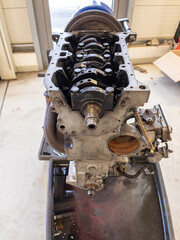 in the garage there is an opened engine block of a car