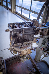 in the garage there is an opened engine block of a car