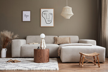 Interior design of stylish living room with modern neutral sofa, mock up poster farmes, dried flowers in vase, coffee tables, decoration and elegant personal accessories in home decor. Template.