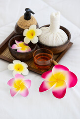 Obraz na płótnie Canvas Set of spa treatments, natural oil, and plumeria flowers