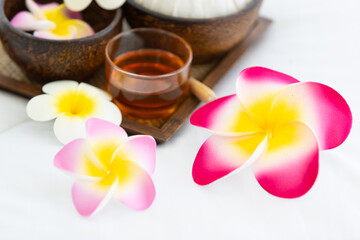 Fototapeta na wymiar Set of spa treatments, natural oil, and plumeria flowers
