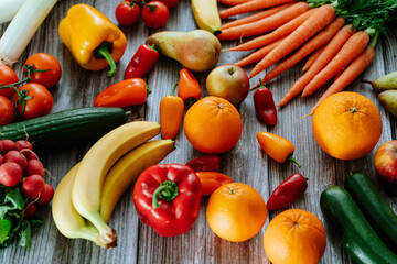 Fresh, healthy, colorful composition from various raw, seasonal fruits and vegetables, food still life on a wooden background