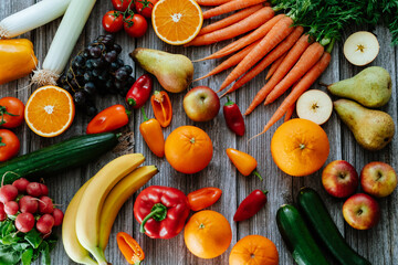 Fresh, healthy, colorful composition from various raw, seasonal fruits and vegetables, food still life on a wooden background