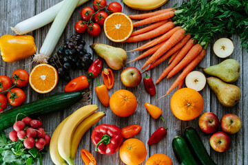 Fresh, healthy, colorful composition from various raw, seasonal fruits and vegetables, food still life on a wooden background