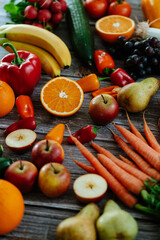Fresh, healthy, colorful composition from various raw, seasonal fruits and vegetables, food still life on a wooden background