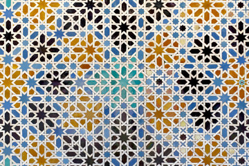 Moorish glazed tiles mosaic pattern in the Alcazar palace of Seville, Spain