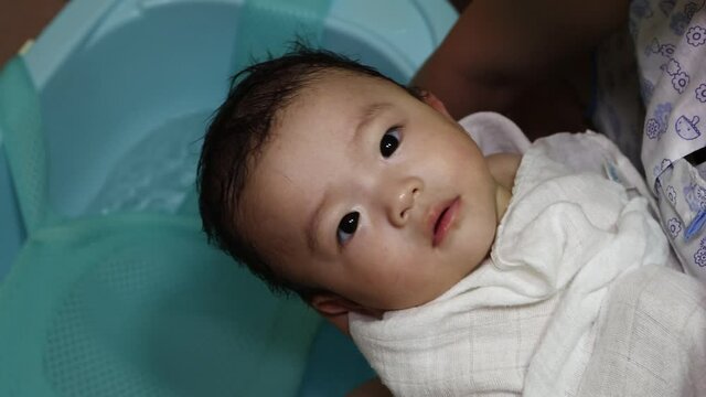 Happy and adorable baby boy playing water during taking a bath