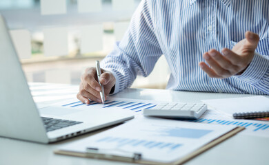 Close up Business man using calculator and laptop for do math finance on wooden desk, tax, accounting, statistics and analytical research concept