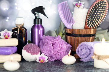 Obraz na płótnie Canvas Bath bomb, orchid flowers, burning candles, towel, massage oil, soap, washcloths, combs, abstract lights. Spa resort therapy composition.