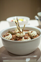 chocolate mousse in a white Cup decorated with chocolate and whipped cream. High quality photo