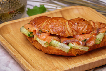 Croissant sandwich with salmon and vegetables
