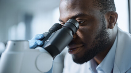 Macro Close Up Shot of a Handsome Excited Black Male Scientist Looking into the Microscope....