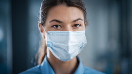 Beautiful Female Wearing a Disposable Protective Face Mask. Her Occupation May be a Doctor, Surgeon, Succesful Entrepreneur or Manager. She Calmly Looks at Camera. Covid-19 Pandemic Concept.