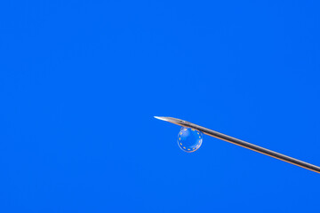 Vaccination in Europe. Needle with a small drop of vaccine against flag of European Union.