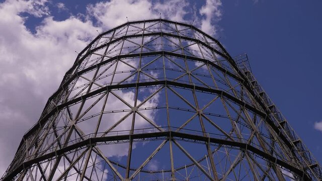 industrial archeology - view of gasometer  with clouds running across the sky