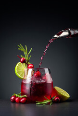 Cranberry cocktail garnished with berries, lime, and rosemary.