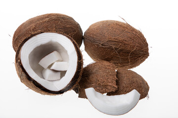 Ripe half coconut and coconut peaces on white background