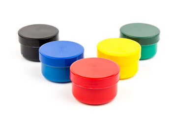Closed plastic jars with paint of different colors for children's creativity on white background....
