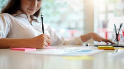 Close-up of young woman hand taking notes at the office.