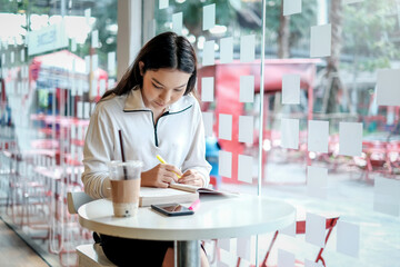 Beautiful Asian woman reading a book at a café.