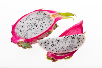 Ripe dragon fruit or pitaya cut in half with seeds visible on white background