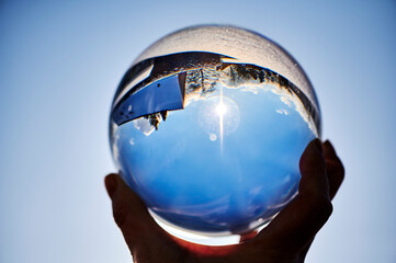 View through a crystal ball onto a winter landscape, which can be seen upside down through the reflection.