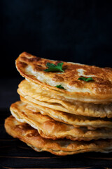 Homemade fried empanadas with pork, chebureks with mushrooms on a wooden board.