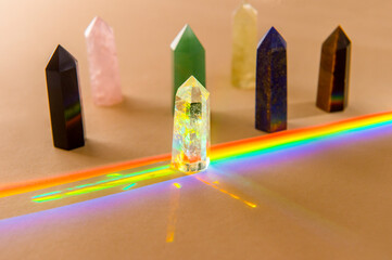 Healing chakra crystals and rainbow on beige background. Meditation, reiki and spiritual healing...
