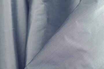 Shiny blue silk fabric is draped. Texture