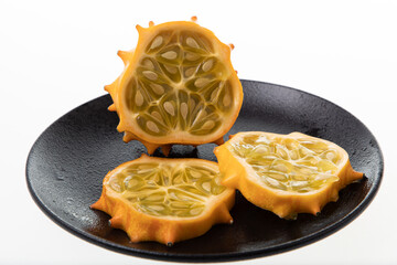 Horned melon (kiwano) sliced on black plate